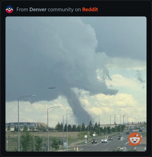 A photo of a southwestern airplane flying past a tornado.