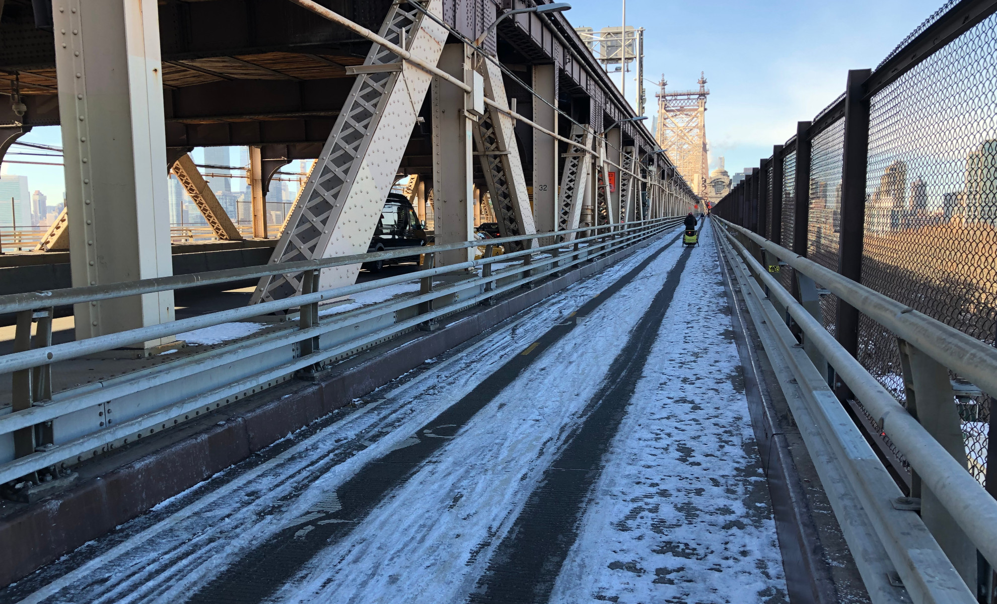 Bridge path covered in snow with two neat trenches from bicycle traffic