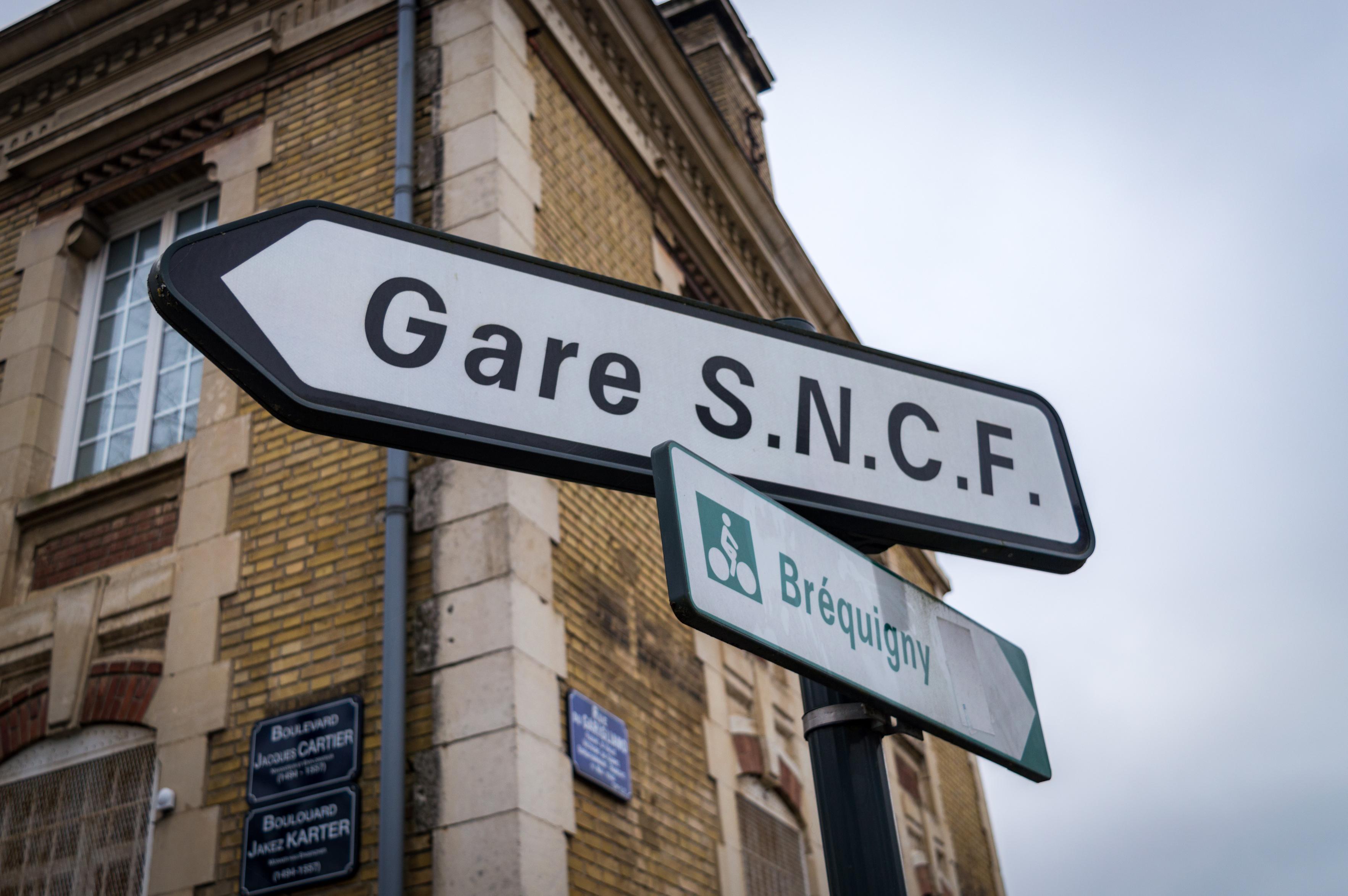 Directional sign, a brick building in the background